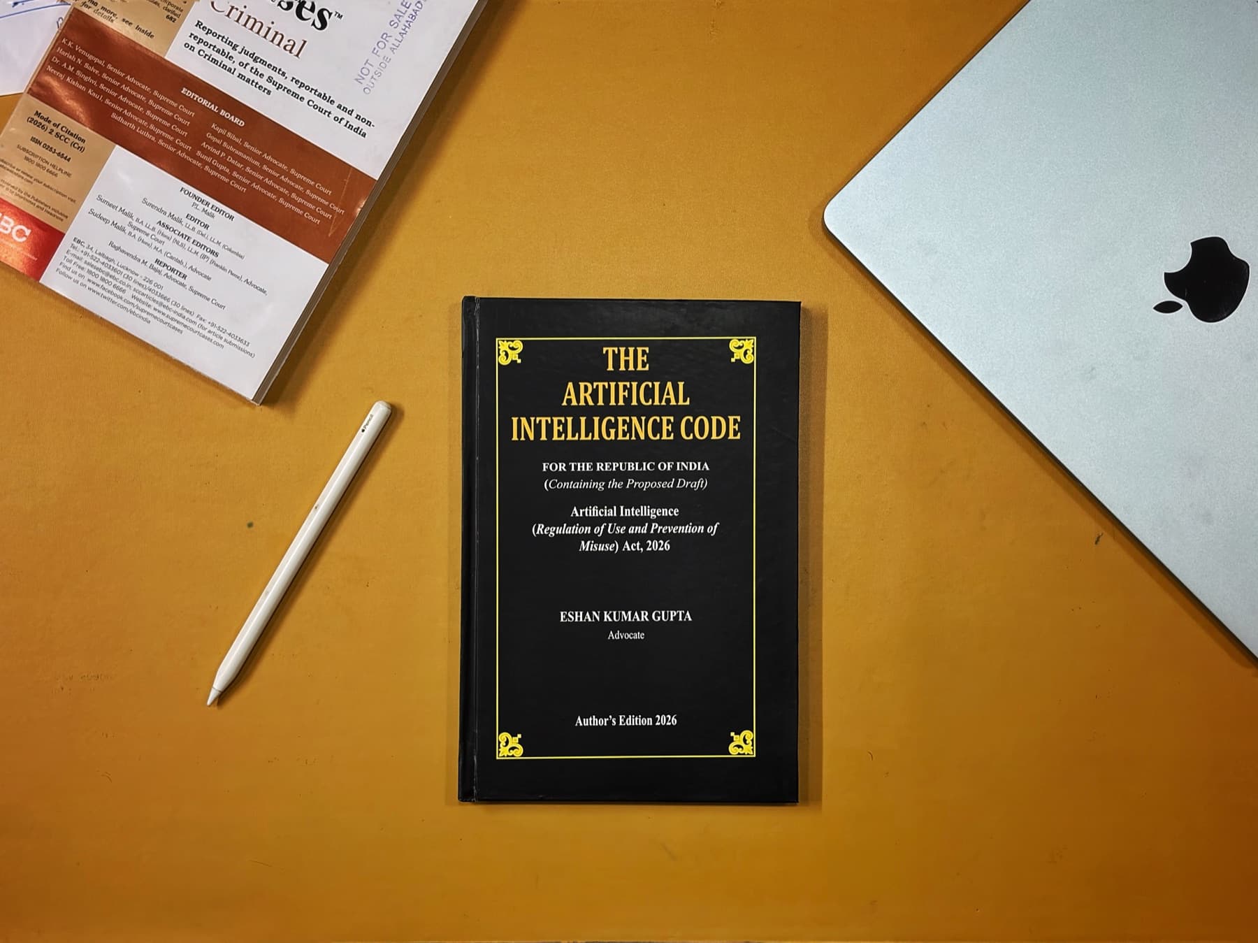 The Artificial Intelligence Code, 2026, bound in black boards with gilt lettering, on a desk beside a volume of the Supreme Court Cases reports.